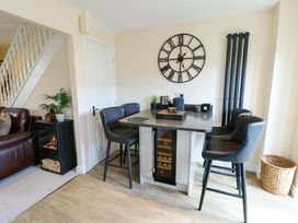 A dining room with a table and stools at 20 Cysgod Y Bryn in Rhos-On-Sea