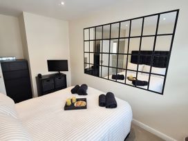A bedroom with a bed and a mirror at Hafan Rhos in Rhos-On-Sea