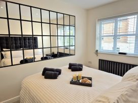 A bedroom with a bed, towels on the bed and a tray with candles and cookies at Hafan Rhos Rhos-On-Sea