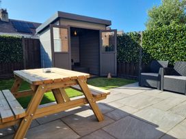 A garden with a shed and seating area at Hafan Rhos in Rhos-On-Sea