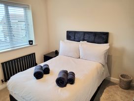 A bedroom with a bed and towels arranged at Hafan Rhos in Rhos-On-Sea