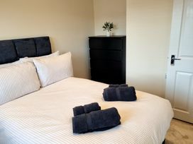 A bedroom with a bed and towels at Hafan Rhos in Rhos-On-Sea