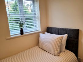 A bedroom with a bed and plant by the window at Hafan Rhos Rhos-On-Sea
