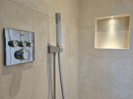 A shower setup with control panel and handheld showerhead at Hafan Rhos in Rhos-On-Sea
