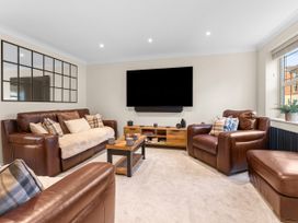 A living room with leather sofas and a television at Hafan Rhos in Rhos-On-Sea