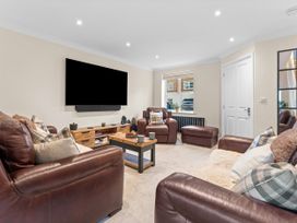 A living room with leather sofas and a television at Hafan Rhos Rhos-On-Sea
