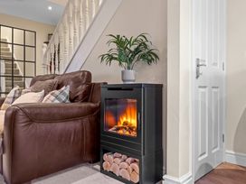 A living room with a sofa and an electric fireplace at Hafan Rhos in Rhos-On-Sea