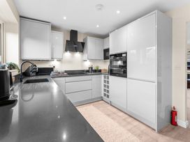 A kitchen with modern appliances and cabinets at Hafan Rhos in Rhos-On-Sea