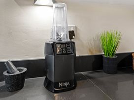 A blender and kitchen accessories on a countertop at Hafan Rhos in Rhos-On-Sea