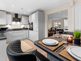 A kitchen with a dining area featuring a table and chairs at Hafan Rhos in Rhos-On-Sea