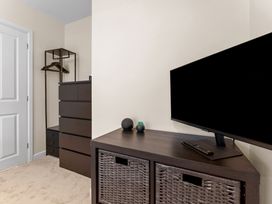 A bedroom with a dresser and television at Hafan Rhos in Rhos-On-Sea