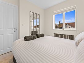 A bedroom with a bed and a mirror at Hafan Rhos in Rhos-On-Sea