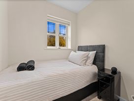 A bedroom with a bed and a window at Hafan Rhos in Rhos-On-Sea