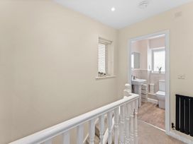 A bathroom with sink and toilet visible from a landing at Hafan Rhos in Rhos-On-Sea