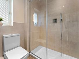 A bathroom with a shower and toilet at Hafan Rhos in Rhos-On-Sea
