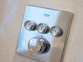 A shower control panel with temperature and flow controls at Hafan Rhos in Rhos-On-Sea