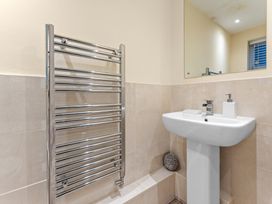 A bathroom featuring a towel radiator and a sink at Hafan Rhos in Rhos-On-Sea