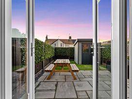 A garden with a table and bench viewed through double doors at Hafan Rhos in Rhos-On-Sea