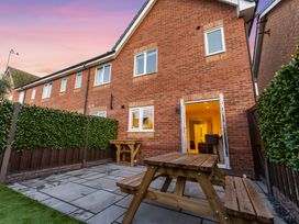 A garden with a table and fence at Hafan Rhos in Rhos-On-Sea