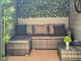 An outdoor seating area with a sectional sofa and a table at Hafan Rhos in Rhos-On-Sea