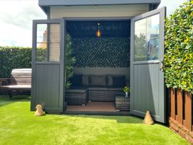 An outdoor shed with a seating area in the garden at Hafan Rhos in Rhos-On-Sea