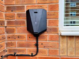 A black box mounted on a brick wall with a pipe at Hafan Rhos, Rhos-On-Sea