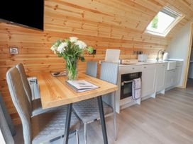 A kitchen with a table and chairs and a television at Pendle in Nelson