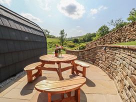 An outdoor seating area with a wooden table and benches at Pendle in Nelson
