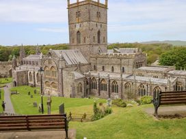 An outdoor area with a church and surrounding gravestones at The Shephard Hut near Nine Wells