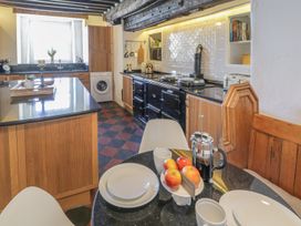 A kitchen with a table and chairs at Bwthyn Morse in Llanfair