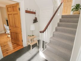 A hallway with a staircase and table at Bwthyn Morse in Llanfair