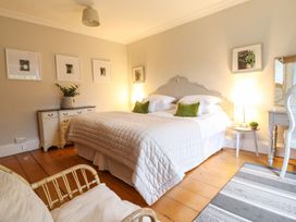 A bedroom with a bed, nightstand, and chair at Bwthyn Morse in Llanfair