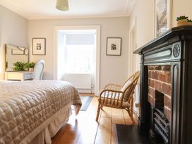 A bedroom with a bed and chair at Bwthyn Morse in Llanfair