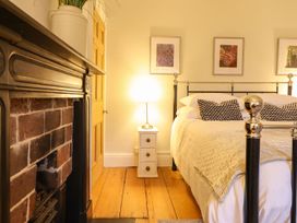 A bedroom with a bed, fireplace and nightstand at Bwthyn Morse Llanfair