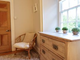 A hallway with a chair and drawers at Bwthyn Morse in Llanfair