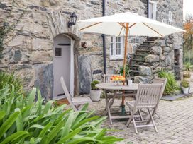 An outdoor dining area with a table and chairs at Bwthyn Canol in Llanfair
