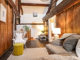 A living room with a sofa and chair at Bwthyn Canol in Llanfair