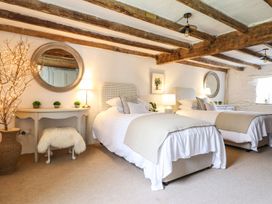 A bedroom with two beds and a nightstand at Bwthyn Canol Llanfair