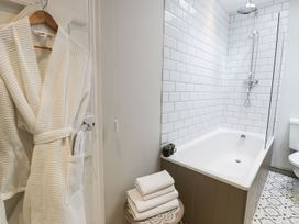 A bathroom with a bath tub and shower at Bwthyn Canol in Llanfair