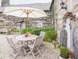 An outdoor patio with a table and chairs at Bwthyn Canol in Llanfair
