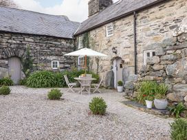 An outdoor seating area with a table and chairs at Bwthyn Canol in Llanfair