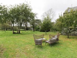 An outdoor seating area with chairs and a table at Bwthyn Canol in Llanfair