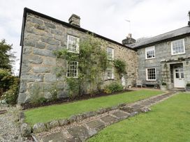 A stone house with a garden and pathway at Bwthyn Canol Llanfair