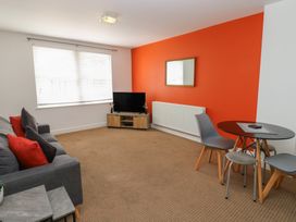 A living room with a sofa and television at Curwen Apartment in Workington