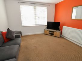 A living room with a sofa and television at Curwen Apartment in Workington
