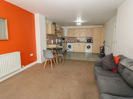 A living room with a kitchen area at Curwen Apartment in Workington
