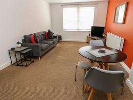 A living room with a sofa and dining table at Curwen Apartment in Workington