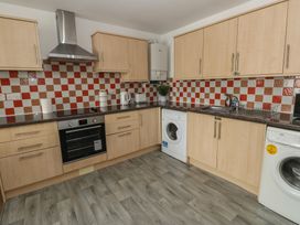 A kitchen with appliances at Curwen Apartment in Workington