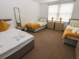 A bedroom with two single beds and one double bed at Curwen Apartment in Workington