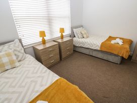 A bedroom with two beds and nightstands at Curwen Apartment in Workington